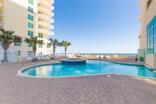 a swimming pool next to a building and the ocean at Crystal Shores West 202 in Gulf Shores