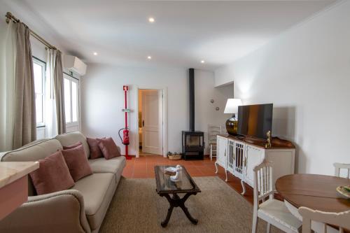 a living room with a couch and a table at Aposento Real Villas in Casa Branca