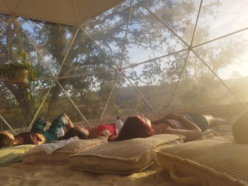 a group of girls laying on beds in a tent at Herdade da Maceira in São Luis
