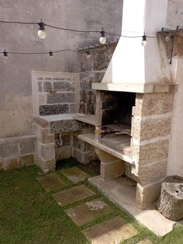 a stone oven in a room with grass at Lisa Dimora Salentina in Andrano