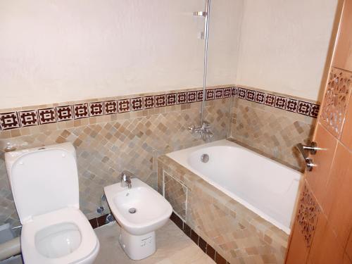 y baño con aseo, bañera, aseo y lavamanos. en 2 bedrooms apartement with city view and garden at Fes, en Fez