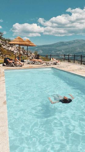 a person swimming in a swimming pool in a swimming pool at Casa do Capucho - Soajo, Gerês in Soajo