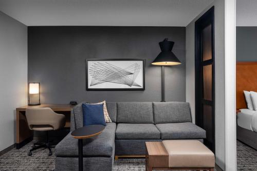 un soggiorno con divano e scrivania di Hyatt Place Detroit/Utica a Utica