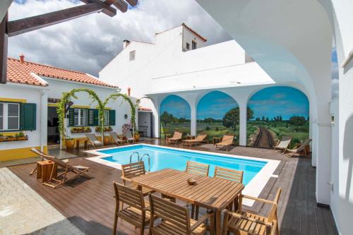 a villa with a swimming pool with a table and chairs at Aposento Real Villas in Casa Branca