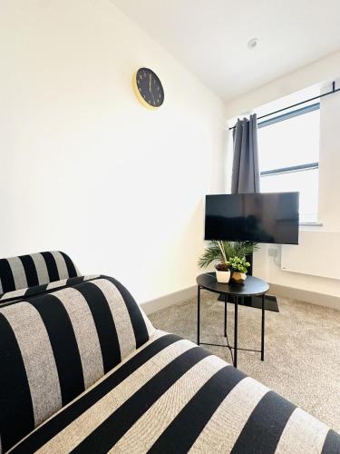 a bedroom with a bed and a clock on the wall at 301 Grosvenor House in Wakefield