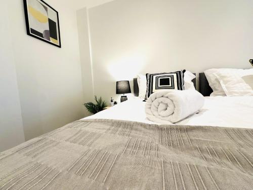 a bedroom with a large bed with white sheets and pillows at 301 Grosvenor House in Wakefield