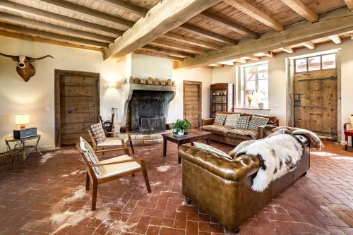 a living room with a couch and a fireplace at La Ferme du Domaine de Bassol - Piscine & Billard in Mézériat