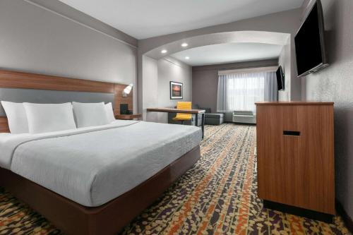 a hotel room with a bed and a flat screen tv at La Quinta by Wyndham Belton - Temple South in Belton