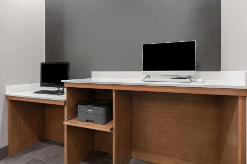 a desk with two monitors and a computer on it at La Quinta by Wyndham Belton - Temple South in Belton