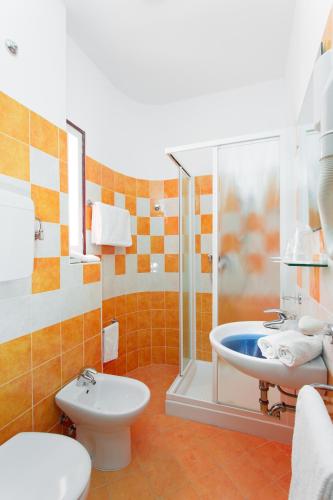a bathroom with a shower and a toilet and a sink at Hotel Meeting in Cesenatico