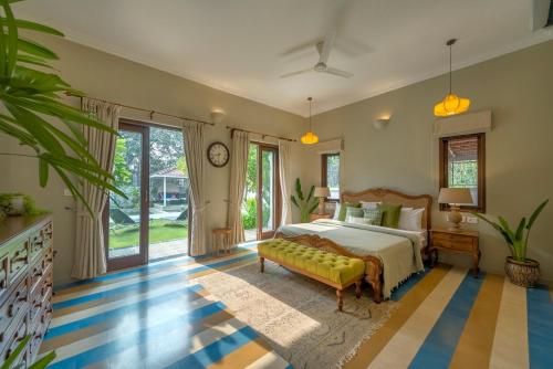 una grande camera da letto con un letto e un divano di SaffronStays Sweet Mango a Goa