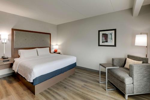 een hotelkamer met een bed en een stoel bij Hampton Inn and Suites Rome, GA in Rome