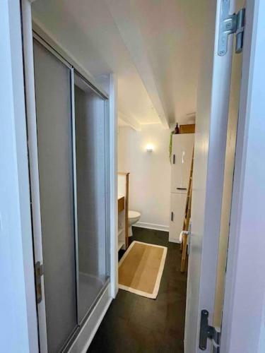 La salle de bains est pourvue d'une porte de douche en verre. dans l'établissement Charmant T1 bis La Rochelle et proche île de Ré, à La Rochelle