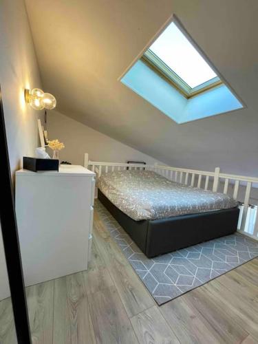 - une chambre mansardée avec un lit et une lucarne dans l'établissement Charmant T1 bis La Rochelle et proche île de Ré, à La Rochelle