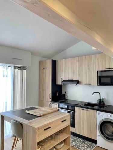 une cuisine avec des armoires en bois et un comptoir dans l'établissement Charmant T1 bis La Rochelle et proche île de Ré, à La Rochelle