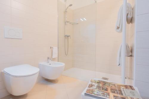 a bathroom with a toilet and a shower and a magazine at Villa Ida - Private Gym & SPA - by Rent All Como in Lenno