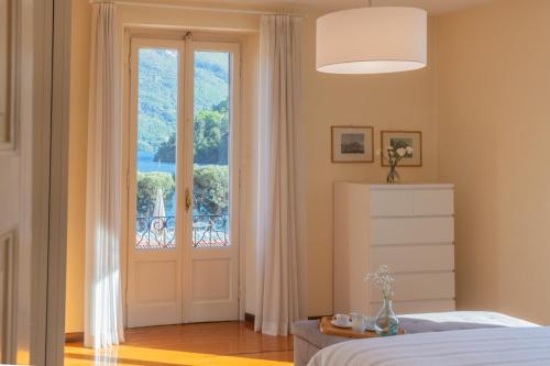 a bedroom with a bed and a large window at Villa Ida - Private Gym & SPA - by Rent All Como in Lenno