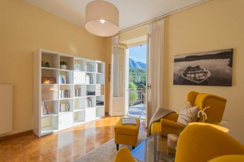 a living room with yellow furniture and a large window at Villa Ida - Private Gym & SPA - by Rent All Como in Lenno