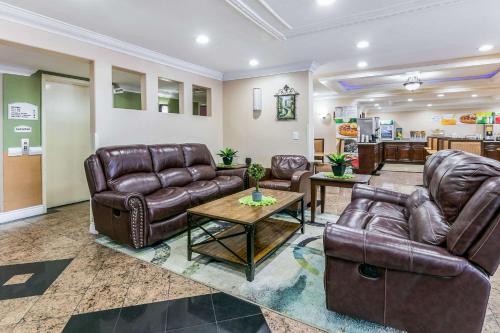 a living room with leather couches and a table at Quality Inn & Suites Atlanta Airport South in Atlanta
