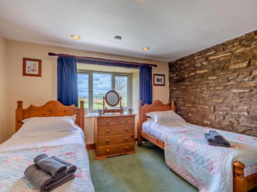 1 dormitorio con 2 camas y pared de piedra en 2 Bed in Kirby Stephen SZ265 en Ravenstonedale