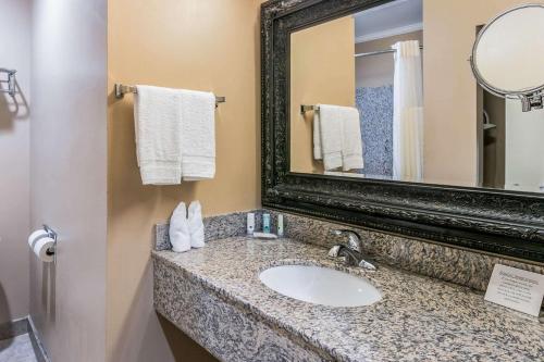 a bathroom with a sink and a mirror and towels at Quality Inn & Suites Atlanta Airport South in Atlanta
