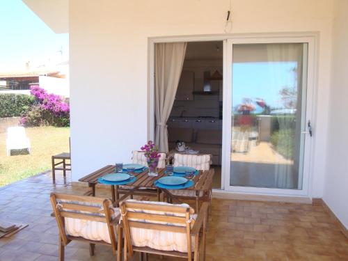 a dining room with a table and chairs and a sliding glass door at Cala Vigliena Il Sole Negli Occhi in Punta Braccetto