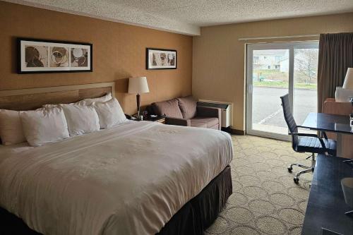 a hotel room with a bed and a desk and a window at Comfort Inn Rimouski in Rimouski