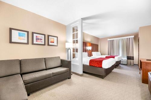 a hotel room with a bed and a couch at Comfort Suites Orlando Airport in Orlando