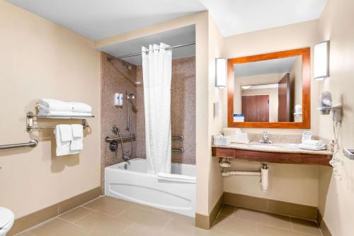 a bathroom with a tub and a toilet and a sink at Comfort Suites Orlando Airport in Orlando