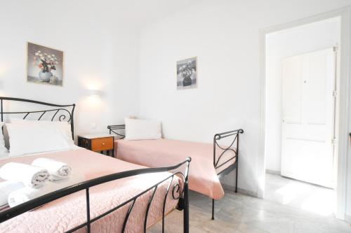 a bedroom with two beds with pink sheets at Asteri Hotel in Ornos