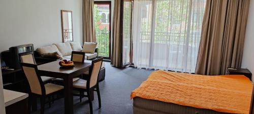 a living room with a bed and a desk and a room at Marina in Aheloy