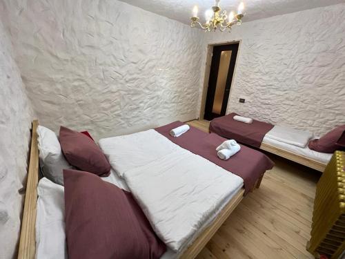 a bedroom with two beds and a chandelier at Qafqaz Suite Paradise Chalet & SPA in Gabala