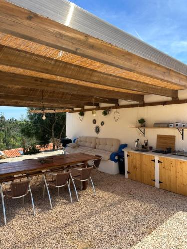 a patio with a table and a kitchen at Herdade da Maceira in São Luis