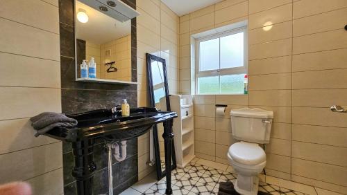 uma casa de banho com um lavatório preto e um WC. em No 2 Atlantic View Ballyshannon em Ballyshannon