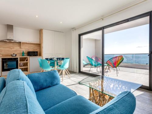 un salon avec un canapé bleu et une table en verre dans l'établissement Apartment La Palangre-1 by Interhome, à Argelès-sur-Mer