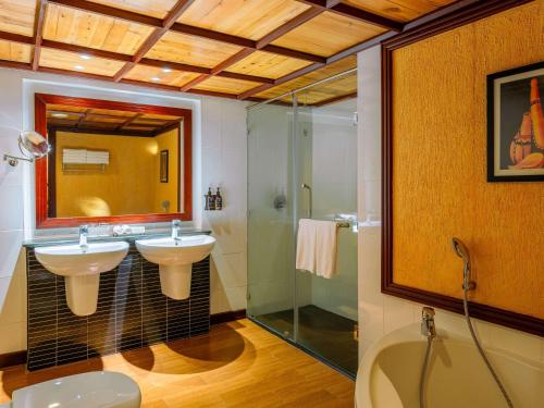 a bathroom with two sinks and a shower at Mövenpick Hotel & Residences Nairobi in Nairobi