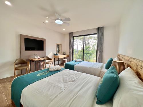 een hotelkamer met 2 bedden en een televisie bij Zephyrus Villa - Standard 2 in Kon Von Kla