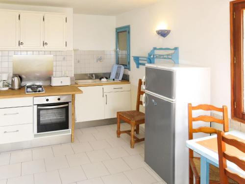 Il comprend une cuisine équipée d'un réfrigérateur, d'une table et de chaises. dans l'établissement Apartment Résidence de la Plage-1 by Interhome, à LʼÎle-Rousse