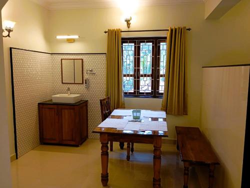 Zimmer mit einem Tisch, einem Waschbecken und einem Tisch in der Unterkunft Cielo in Palolem
