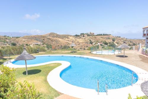 una gran piscina con sombrillas en un complejo en Pool Apt Calahonda 2 with sea view, en Mijas Costa