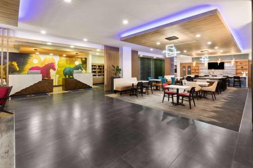a restaurant with tables and chairs in a lobby at La Quinta Inn & Suites by Wyndham El Paso East Loop-375 in El Paso