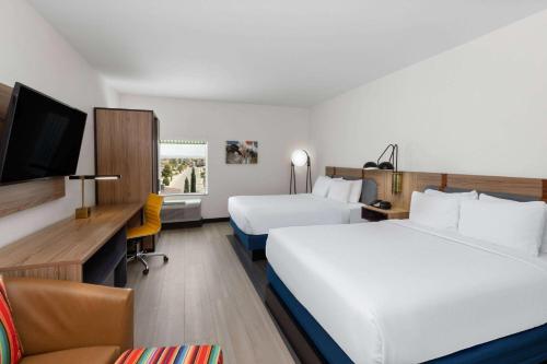 um quarto de hotel com duas camas e uma televisão em La Quinta Inn & Suites by Wyndham El Paso East Loop-375 em El Paso