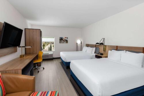 a hotel room with two beds and a tv at La Quinta Inn & Suites by Wyndham El Paso East Loop-375 in El Paso