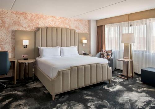 DoubleTree by Hilton Poughkeepsie في باوكيبسي: غرفة نوم مع سرير أبيض كبير في غرفة