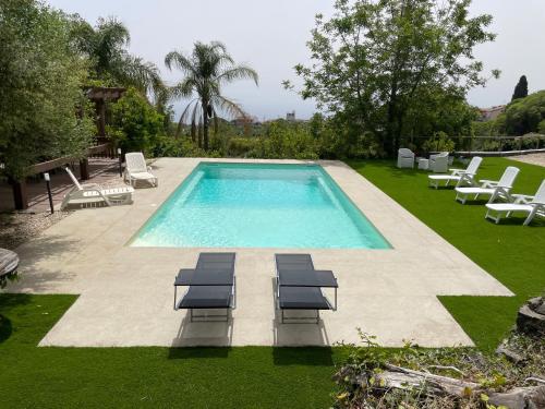 una piscina con tumbonas y tumbonas en un patio en Villa Bonanno Conti, en Valverde