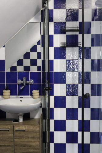 a bathroom with a sink and blue and white tiles at Apartman BUCO in Đakovo