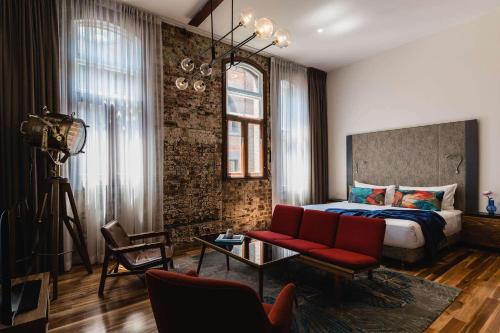 1 dormitorio con 1 cama y 1 sofá rojo en The Old Clare Hotel, Independent Collection by EVT en Sídney