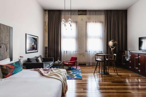 a bedroom with a bed and a living room at The Old Clare by Ode Hotels in Sydney