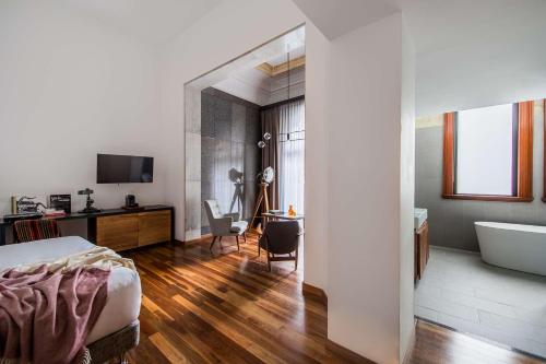a bedroom with a bed and a bathroom with a tub at The Old Clare by Ode Hotels in Sydney