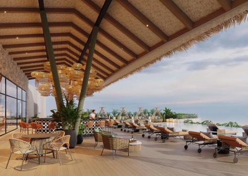 a restaurant with tables and chairs and a view of the water at Zemi Miches Punta Cana All-Inclusive Resort, Curio by Hilton in Miches